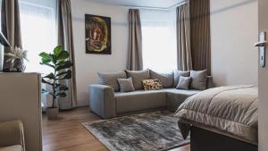 a living room with a couch and a bed at Rosegarden Apartman in Sárospatak