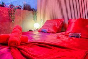 a large red bed with red sheets and pillows at Expérience des sens in Grézieu-la-Varenne