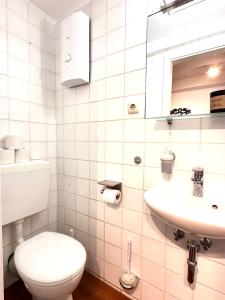 a white bathroom with a toilet and a sink at Die Stader Sehnsucht in Stade