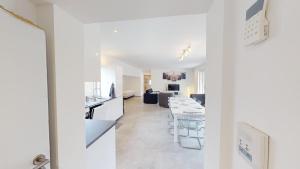 a white kitchen and living room with a table at Le Chalet avec Piscine - Obernai in Obernai