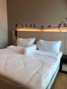 a large white bed with white sheets and pillows at Backpackers Cozy Apartment Bukit Bintang in Kuala Lumpur