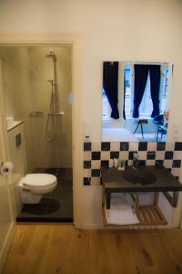 a bathroom with a toilet and a shower and a sink at Amsterdam Rembrandt Square city center Hotel in Amsterdam