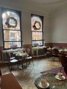 un comedor con mesas, sillas y ventanas en Boutique Hotel Marie Marie en Dendermonde