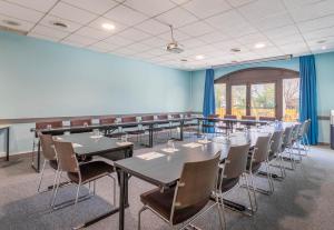 une salle de classe avec des tables et des chaises dans une salle aux murs bleus dans l'établissement B&B HOTEL Marseille La Valentine Porte d'Aubagne, à Marseille