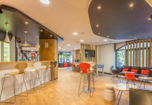 a lobby with tables and chairs and a bar at B&B HOTEL Marseille La Valentine Porte d'Aubagne in Marseille