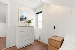 a bedroom with white walls and a bed and a dresser at 3 Bedroom Appartment Close To The Technologypark and University in Kongsberg