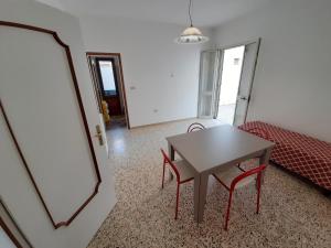 un salon avec une table et un lit dans l'établissement Trilocale Pescoluse fronte mare, à Marina di Pescoluse