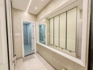 een badkamer met een inloopdouche en een spiegel bij Luxe Apartment in Hyderabad