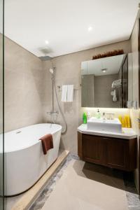 een badkamer met een bad en een wastafel bij Muse Hanoi T-Place Apartment - Hoan Kiem Center in Hanoi
