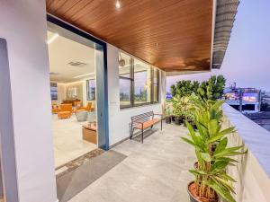 een huis met een veranda met een bank en een plant bij Luxe Apartment in Hyderabad