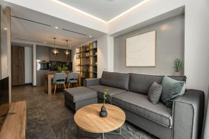 a living room with a couch and a table at Omikron Luxury Residences by Semavί in Heraklio