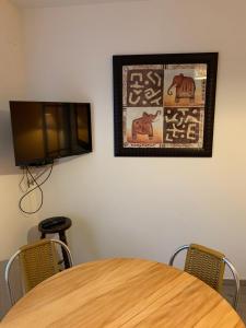 une table avec des chaises et une télévision murale dans l'établissement Les Amis de Beauval, à Seigy