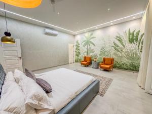 een slaapkamer met een bed en 2 oranje stoelen bij Luxe Apartment in Hyderabad