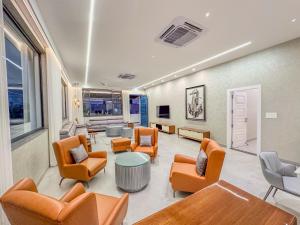 een wachtkamer met oranje stoelen en een tafel bij Luxe Apartment in Hyderabad