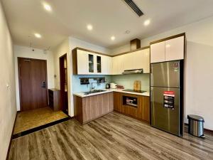 Una cocina con suelos de madera y un refrigerador de acero inoxidable. en BEU Home Tay Ho, en Hanói
