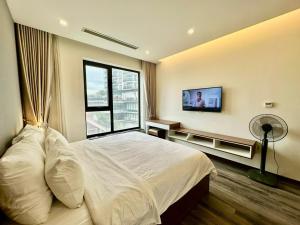Un dormitorio con una cama y un televisor en la pared. en BEU Home Tay Ho, en Hanói