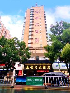 un grand bâtiment avec un panneau devant lui dans l'établissement Century Hotel Tongren, à Tongren