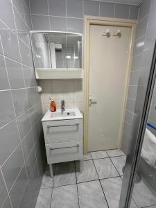 uma casa de banho com um lavatório, um espelho e uma porta em Amiénoise 5 chambres proche Centre Ville em Amiens