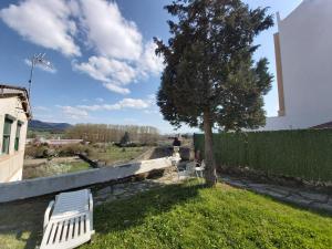 a white bench sitting in the grass next to a tree at CASITA ENFRENTE DEL CASTILLO DE MEDINA in Medina de Pomar