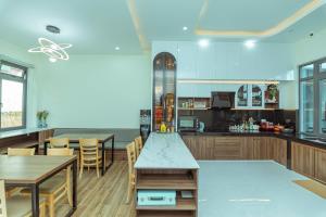 una cucina con tavoli e sedie in legno e un bancone di Hoàng Hiệp Villa a Da Lat Altre 39 foto