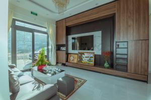 a living room with a couch and a tv at Hoàng Hiệp Villa in Da Lat