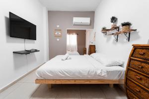 a bedroom with a bed and a flat screen tv at Mellow Bay in Eilat