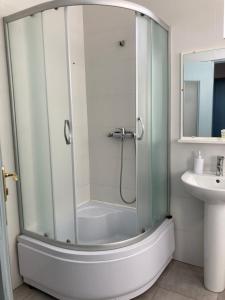 La salle de bains est pourvue d'une douche avec une porte en verre. dans l'établissement Green Kitchen Apartments, à Moukatcheve