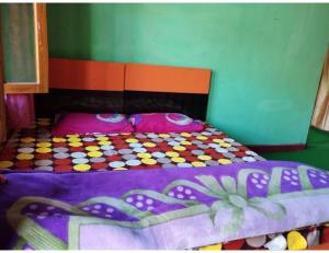 a bedroom with a colorful bed with a colorful comforter at Nk Brothers Homestay, Joshimath in Joshīmath