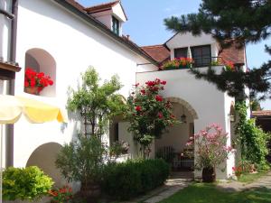 a white house with flowers in a yard at Gästehaus Hans Moser in Purbach am Neusiedlersee