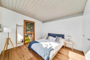 ein weißes Schlafzimmer mit einem Bett und einem Fenster in der Unterkunft Villa Rose in the center of Montreux by GuestLee in Montreux
