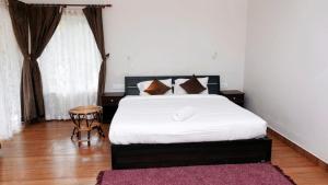 A bed or beds in a room at PRIYAS VILLA VAGAMON