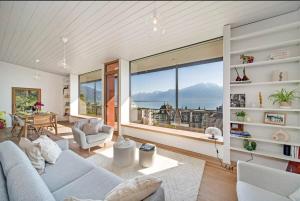 a living room with a couch and a large window at Villa Rose in the center of Montreux by GuestLee in Montreux