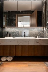 une salle de bain avec un lavabo et un miroir dans l'établissement Omikron Luxury Residences, à Héraklion