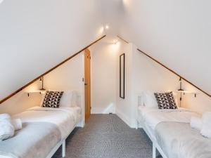 two beds in a room with white walls at Cedar Lodge in Mansfield Woodhouse