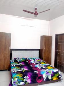 a bed with a colorful blanket on it in a room at SHUBHAM VILLA -- Super Deluxe Rooms -- LPU Law Gate in Phagwāra