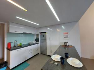 eine Küche mit weißen Schränken und einer Arbeitsplatte in der Unterkunft KL Sentral Loft, EST Bangsar #3, LRT in Kuala Lumpur