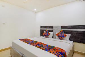 a bedroom with a bed with a colorful blanket on it at FabHotel Ambika Elite in Vijayawāda