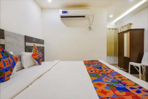 um quarto com uma cama com um cobertor colorido em FabHotel Ambika Elite em Vijayawada