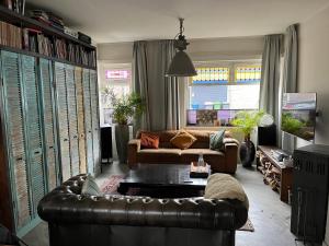 a living room with a leather couch and a table at City centre apartment in Apeldoorn