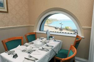 a table in a restaurant with a large window at Cliffe Norton in Tenby