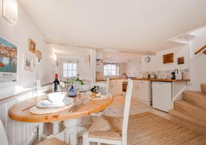 een keuken en eetkamer met een tafel en stoelen bij Jasmine Cottage in Brixham