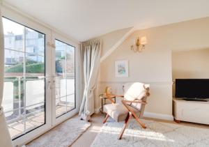 een woonkamer met een stoel en een televisie bij Jasmine Cottage in Brixham