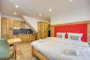 a bedroom with a large bed with a red headboard at Apartments Viktor in Rateče