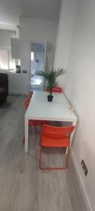 a white table with a red chair and a plant at Travel and Holidays San Nicolas in San Sebastián de los Reyes