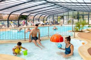 un grupo de personas jugando en una piscina en Mobilhome 3 étoiles - Parc aquatique - eeifcg, en Fouesnant