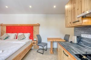małą sypialnię z łóżkiem i kuchnią w obiekcie Apartments Viktor w mieście Rateče