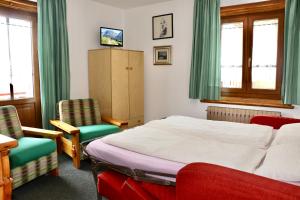 a bedroom with a bed and two chairs at Appartamenti - Formula Roulette in Livigno