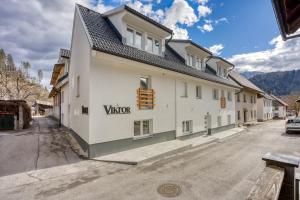 a white building with a sign on the side of it at Apartments Viktor in Rateče