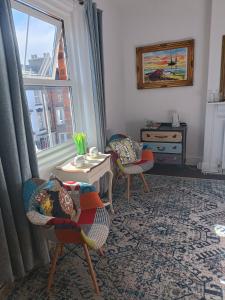 a living room with two chairs and a table and a window at Harbour View B&B in Bridlington