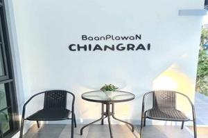 2 Stühle und ein Tisch in einem Zimmer mit Fenster in der Unterkunft Baan Plawan Resort Chiang Rai in Chiang Rai
